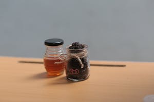 Glass jars with honey and a scrub on a wooden surface, perfect for health or spa themes.